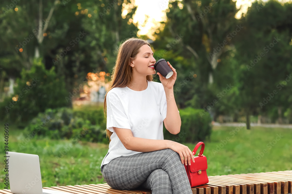 Beautiful young businesswoman relaxing in park