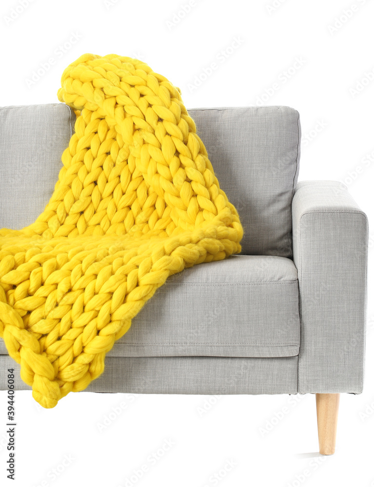 Sofa with knitted plaid on white background