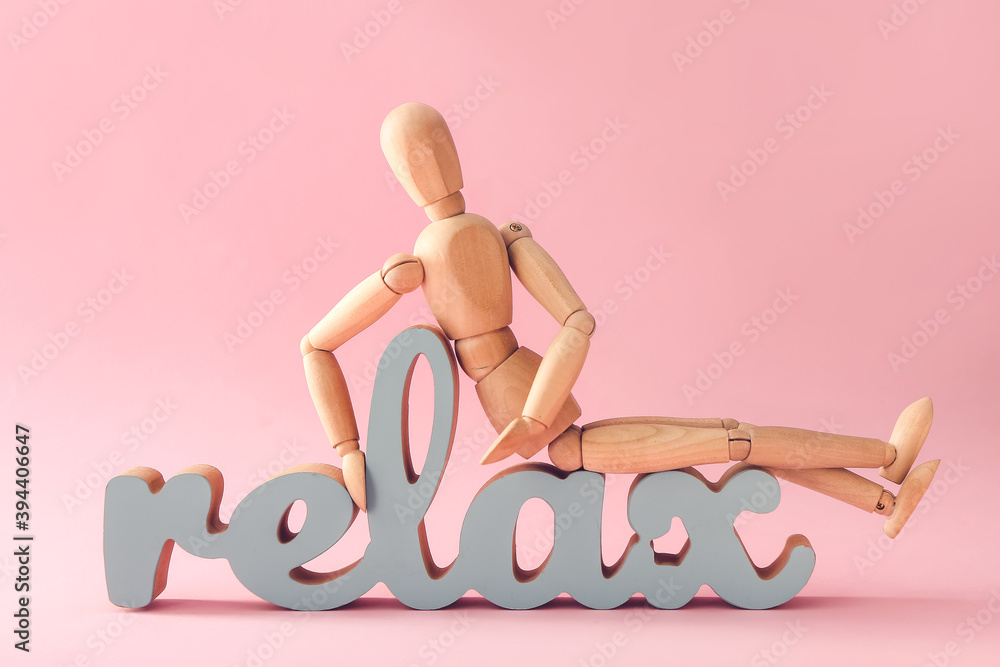 Wooden mannequin with word RELAX on color background