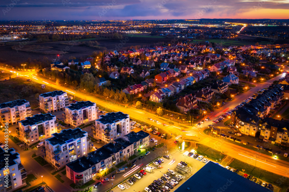 Aerial landscape of illuminated streets of small town in Poland at dusk.