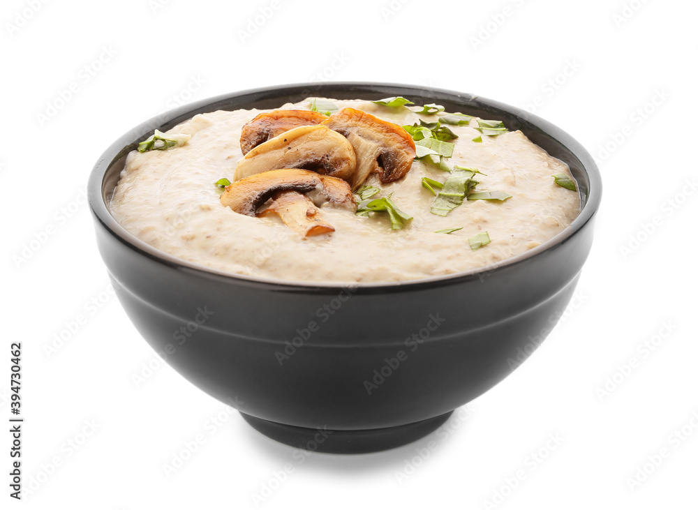 Bowl of tasty mushroom cream soup on white background