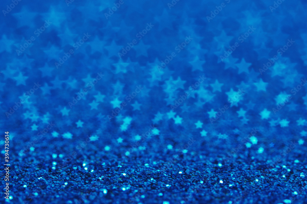 Blue holiday glitter background with stars bokeh.