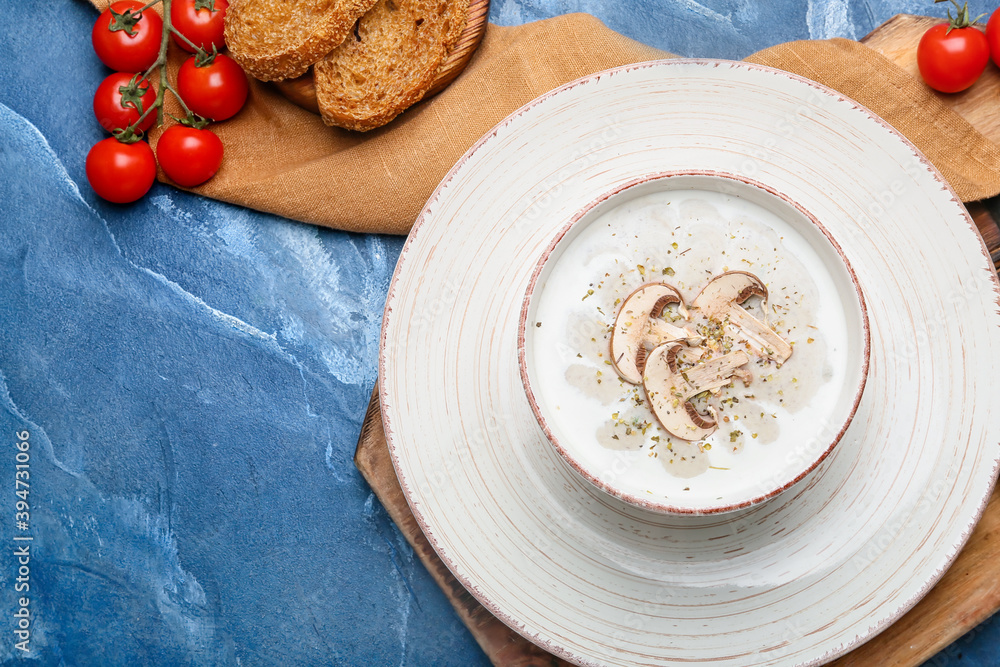 Bowl of tasty mushroom cream soup on  color background