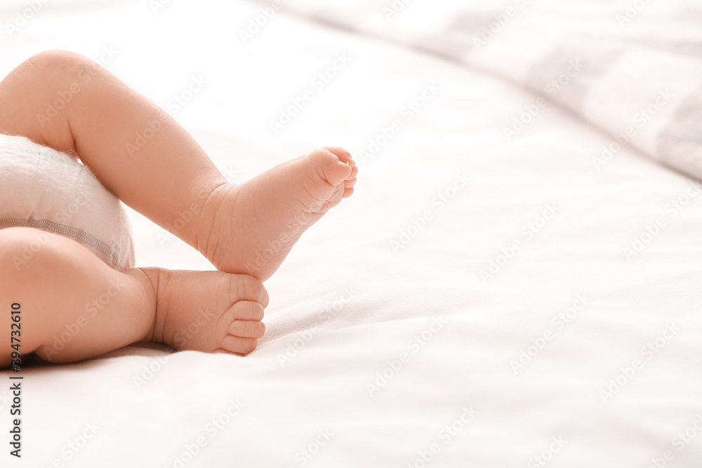 Legs of cute little baby lying on bed