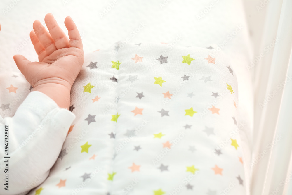 Hand of cute little baby lying on bed