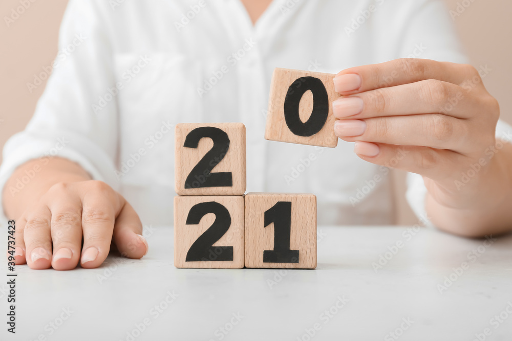 Woman and cubes with 2021 on table