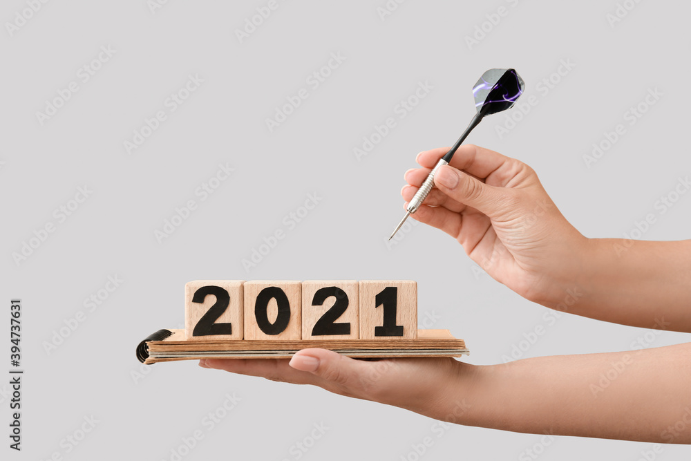 女性手拿立方体，2021图案，笔记本和轻薄背景上的省道