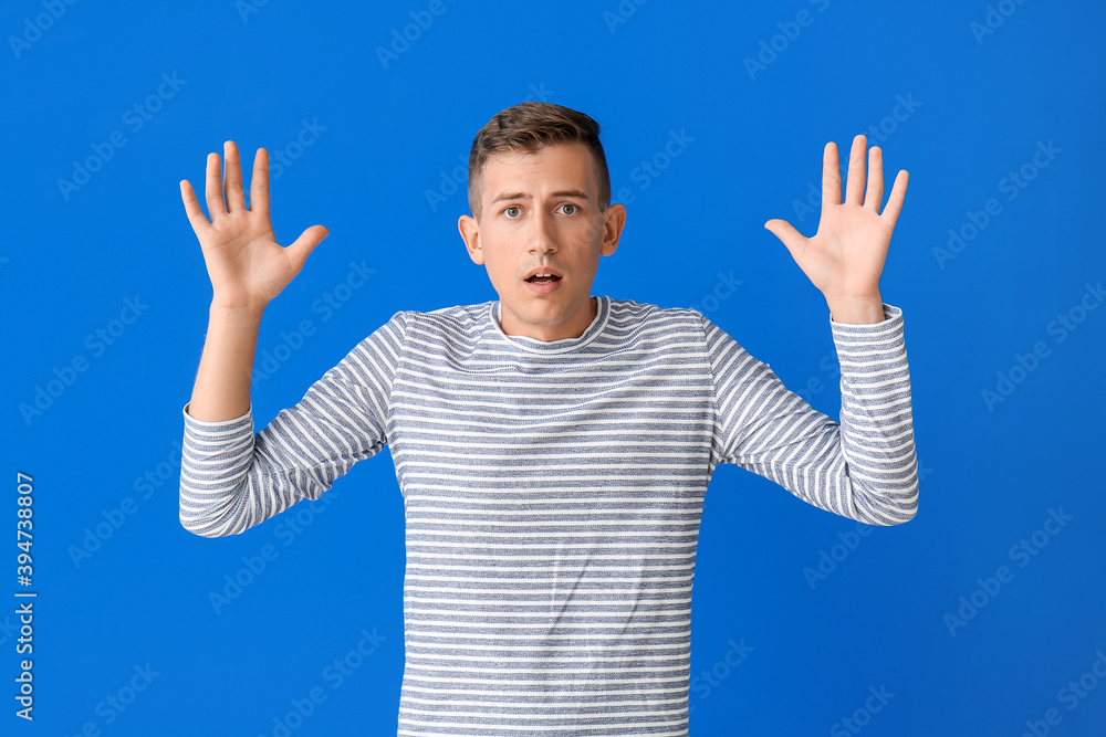 Scared young man on color background