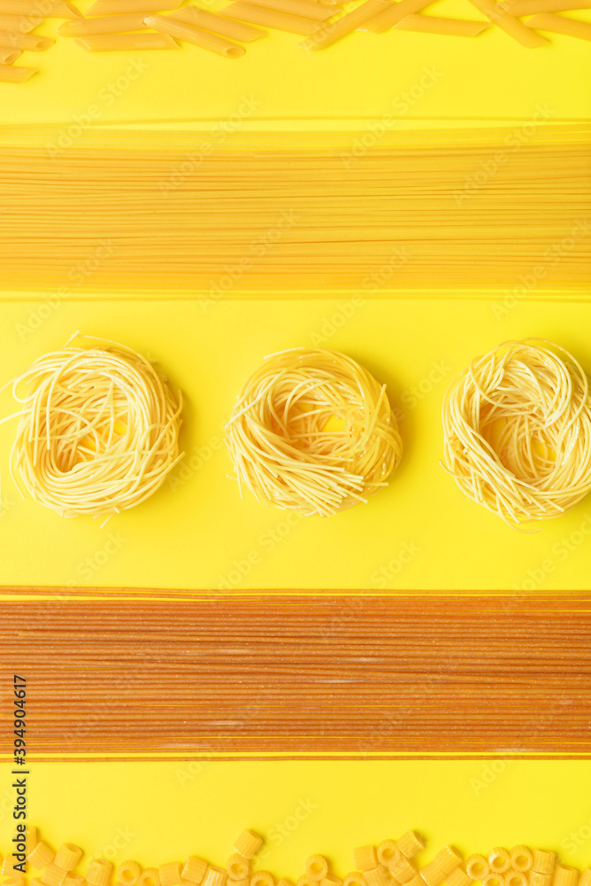 Composition with different uncooked pasta on color background