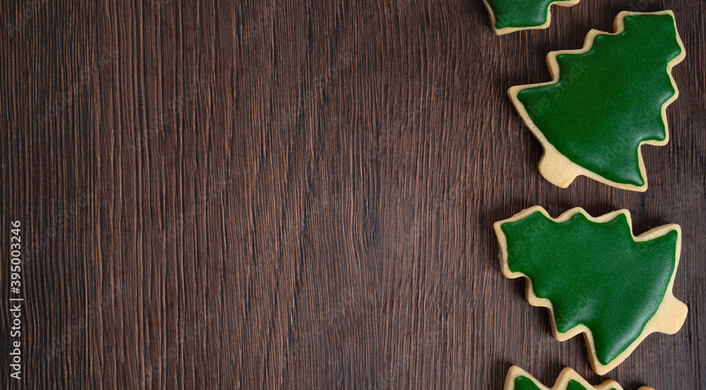 Top view of decorated Christmas tree cookie on wooden table background with copy space.