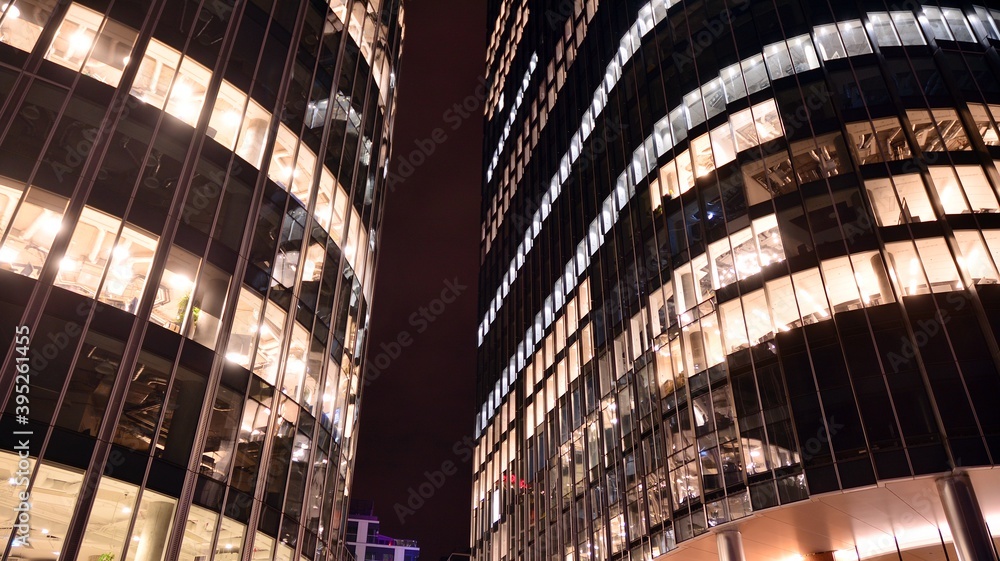 Pattern of office buildings windows illuminated at night. Lighting with Glass architecture facade de