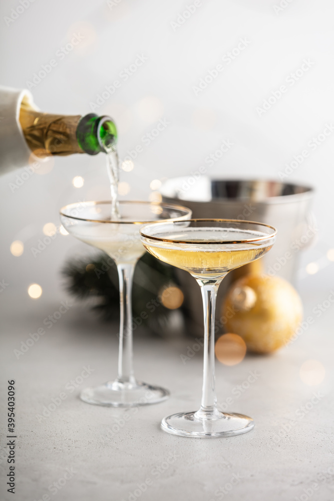 Champagne pouring into glasses and Christmas decorations