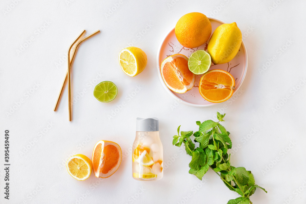 Bottle of mint infused water with citruses on white background