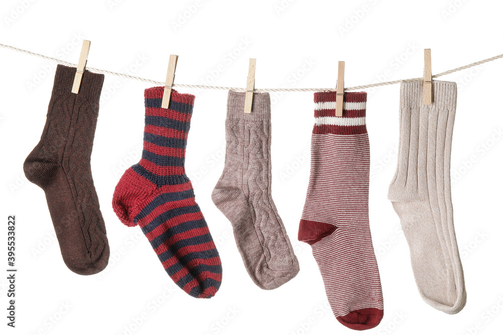 Warm socks hanging on clothes line against white background