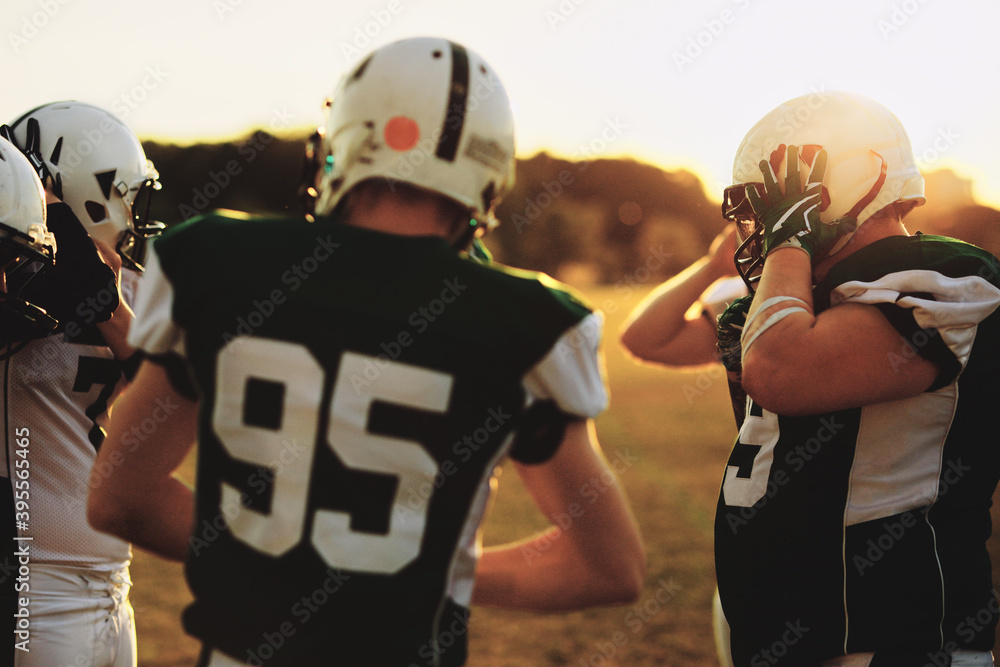 Team of American football players talking during an afternoon pr