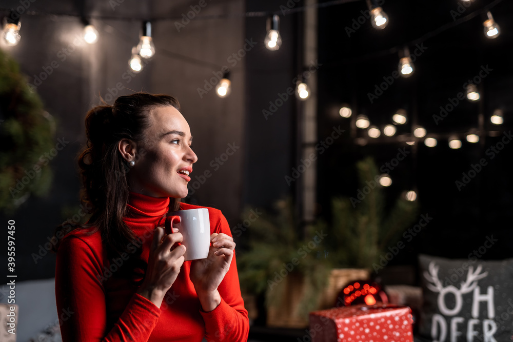 Beautiful woman in love drinking tea on a Christmas. Rest on Christmas holidays in decorated room.