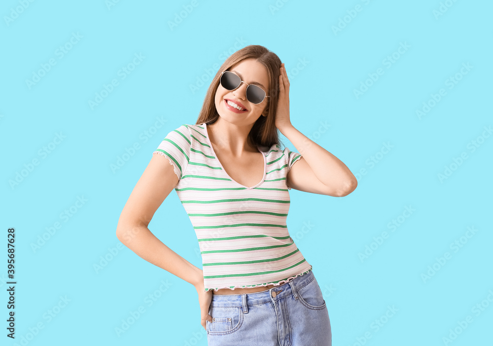 Beautiful woman with stylish sunglasses on color background