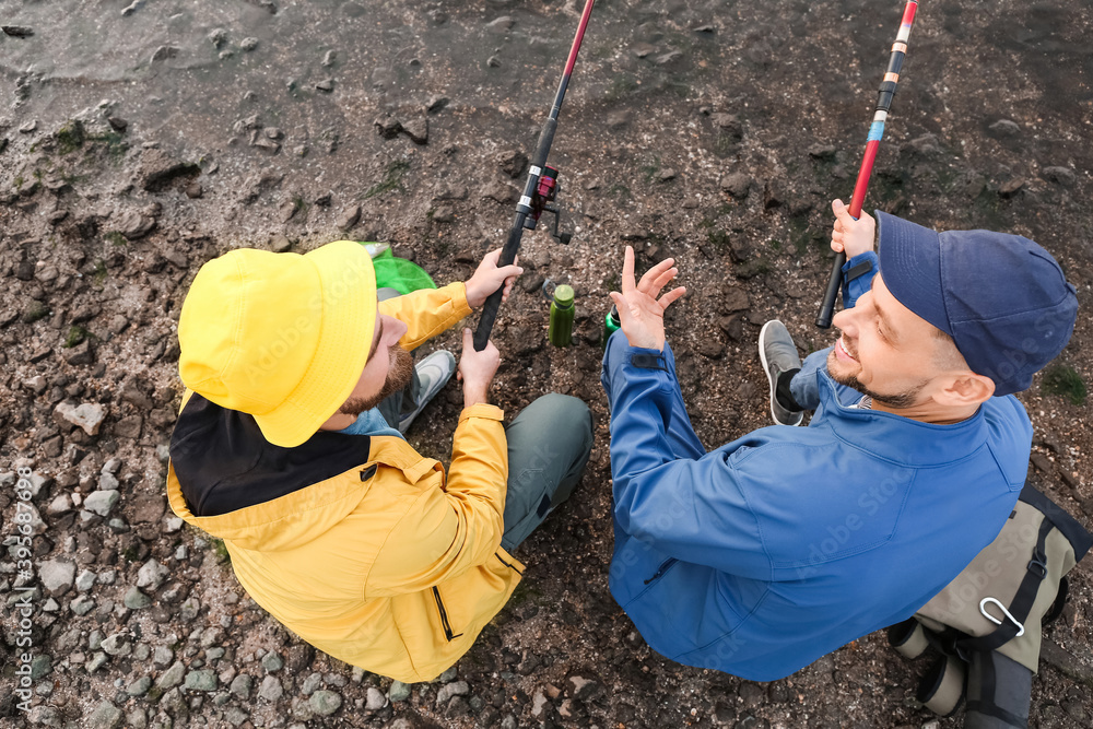 Young men fishing on river