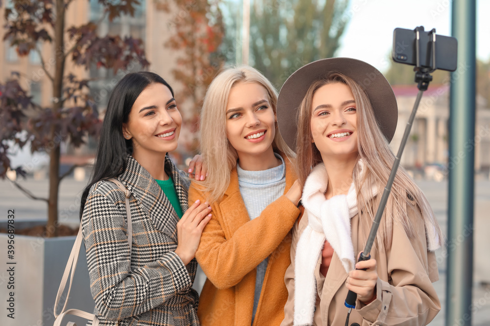 Beautiful young women taking selfie outdoors