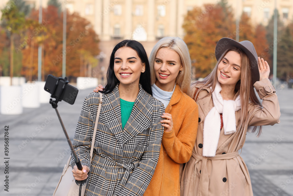 Beautiful young women taking selfie outdoors