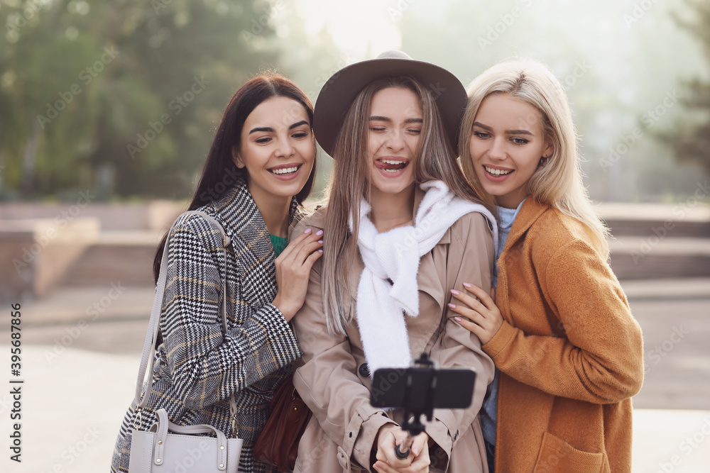 Beautiful young women taking selfie outdoors