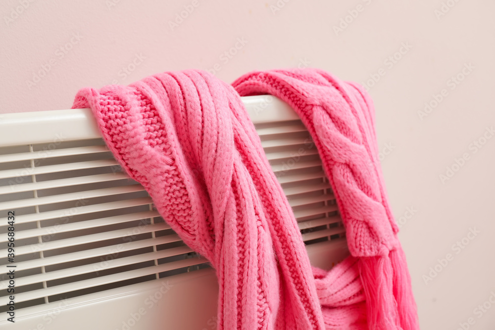 Warm scarf on radiator. Concept of heating season