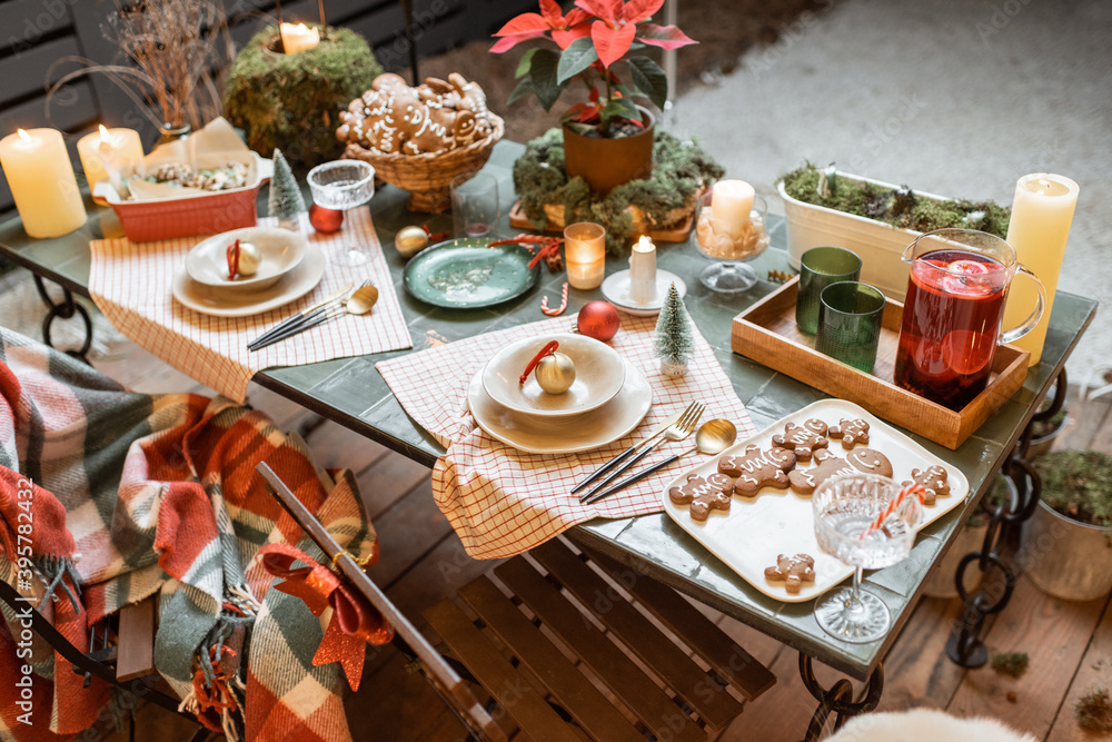 Beautifully decorated dinner table on the terrace outdoors during the New Year holidays