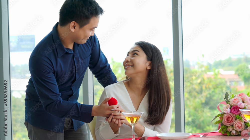 Romantic couple giving gift to lover at restaurant . Happy couple lifestyle .