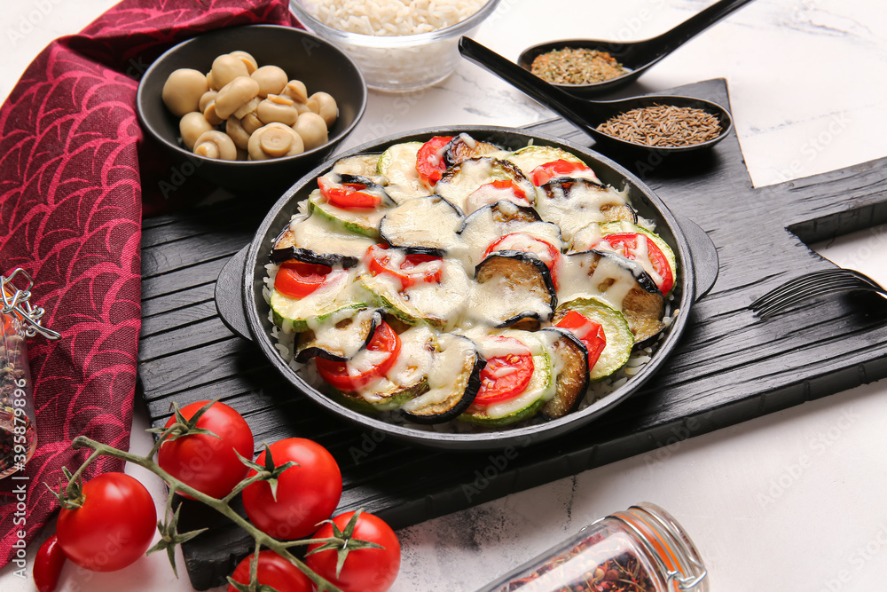 Baking dish with tasty rice casserole on table