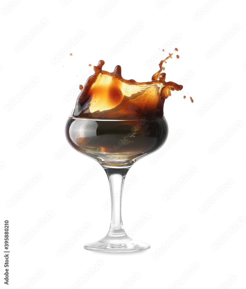 Glass of tasty espresso martini cocktail with splashes on white background