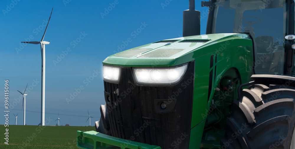 Agricultural tractor on a background of a wind turbines	