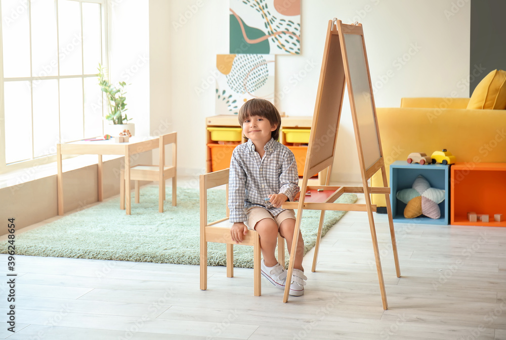 幼儿园画架附近可爱的小男孩