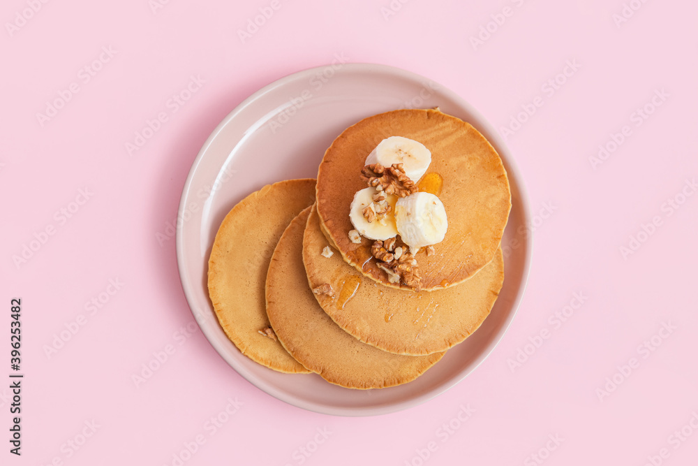 Tasty banana pancakes on color background