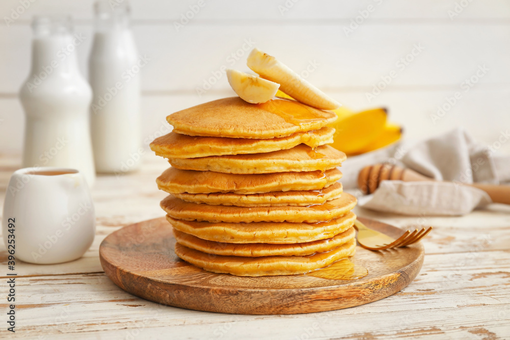 Plate with tasty banana pancakes on table