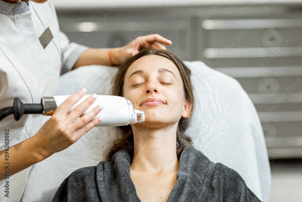 Portrait of a young woman during a facial rejuvenation treatment at medical SPA. LaseMD procedure co