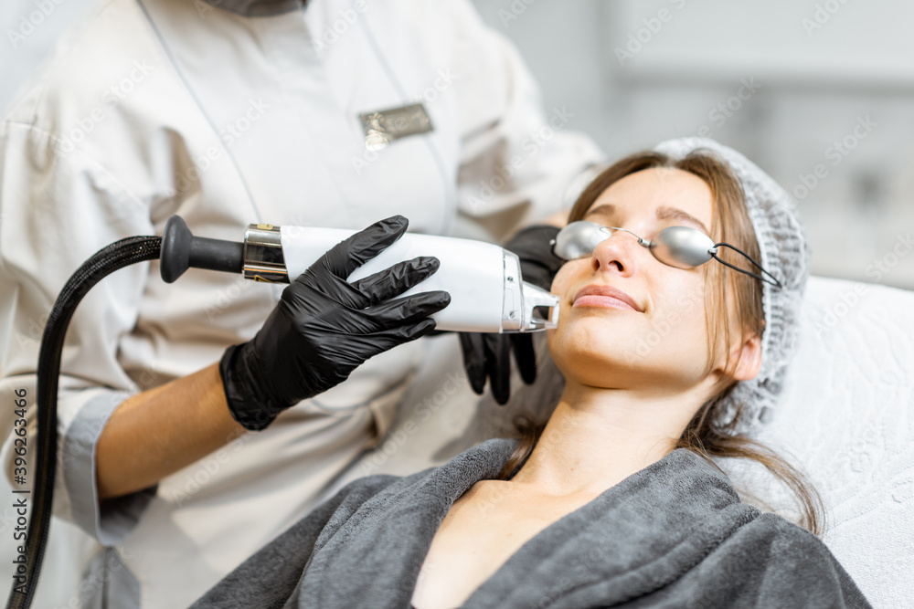 Portrait of a young woman during a facial rejuvenation treatment at medical SPA. LaseMD procedure co