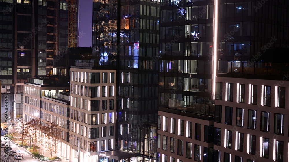 Pattern of office buildings windows illuminated at night. Lighting with Glass architecture facade de