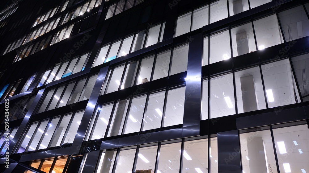 Pattern of office buildings windows illuminated at night. Lighting with Glass architecture facade de