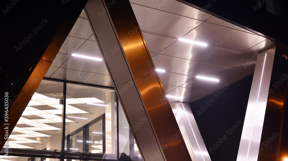 Combination of metal and glass wall material. Steel facade on columns. Abstract modern architecture.