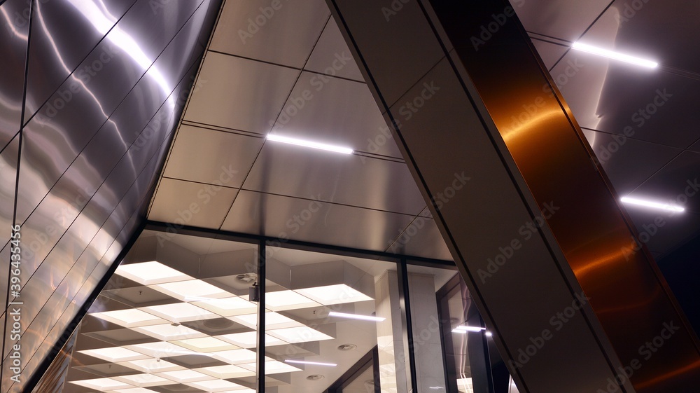 Combination of metal and glass wall material. Steel facade on columns. Abstract modern architecture.