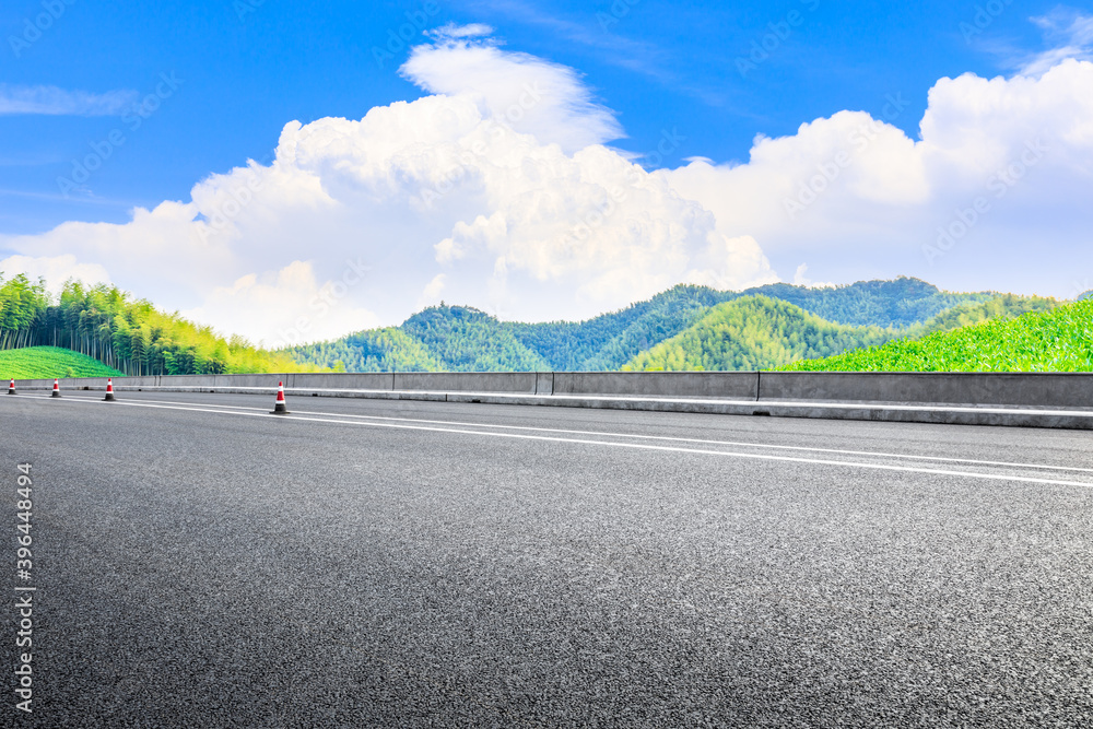 Asphalt road and green mountain with bamboo forest natural landscape.