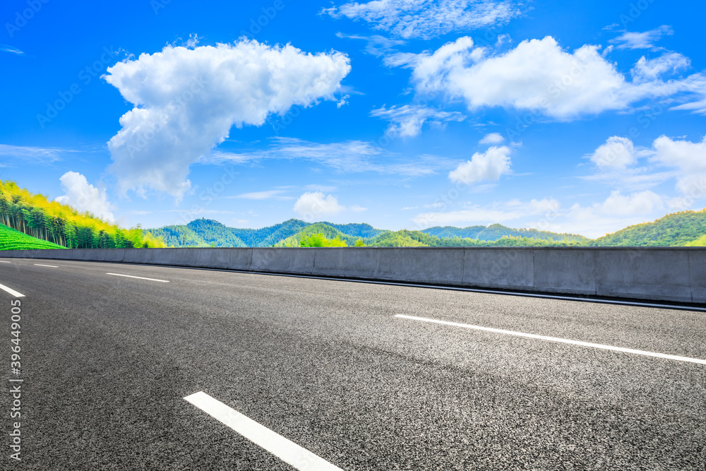 Asphalt road and green mountain with bamboo forest natural landscape.