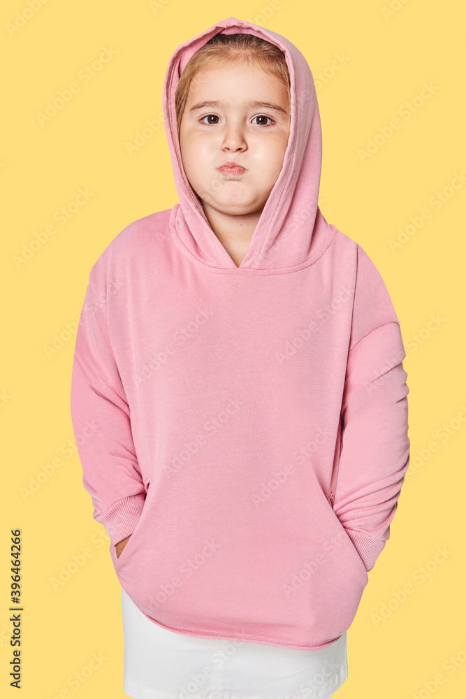 Little cute girl in pink hoodie in studio