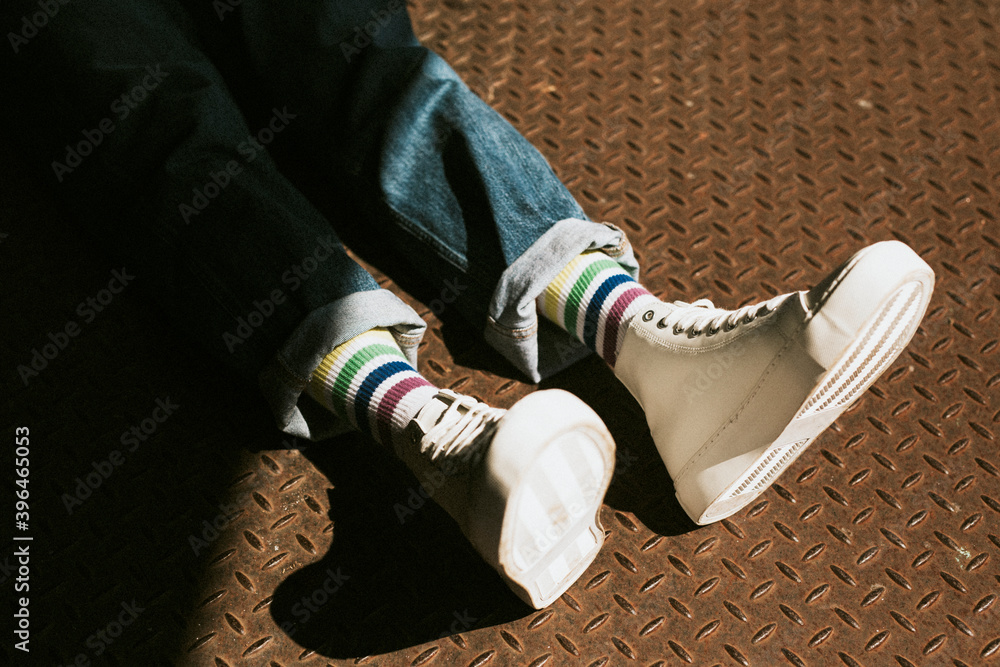 White high top canvas shoes on jeans model