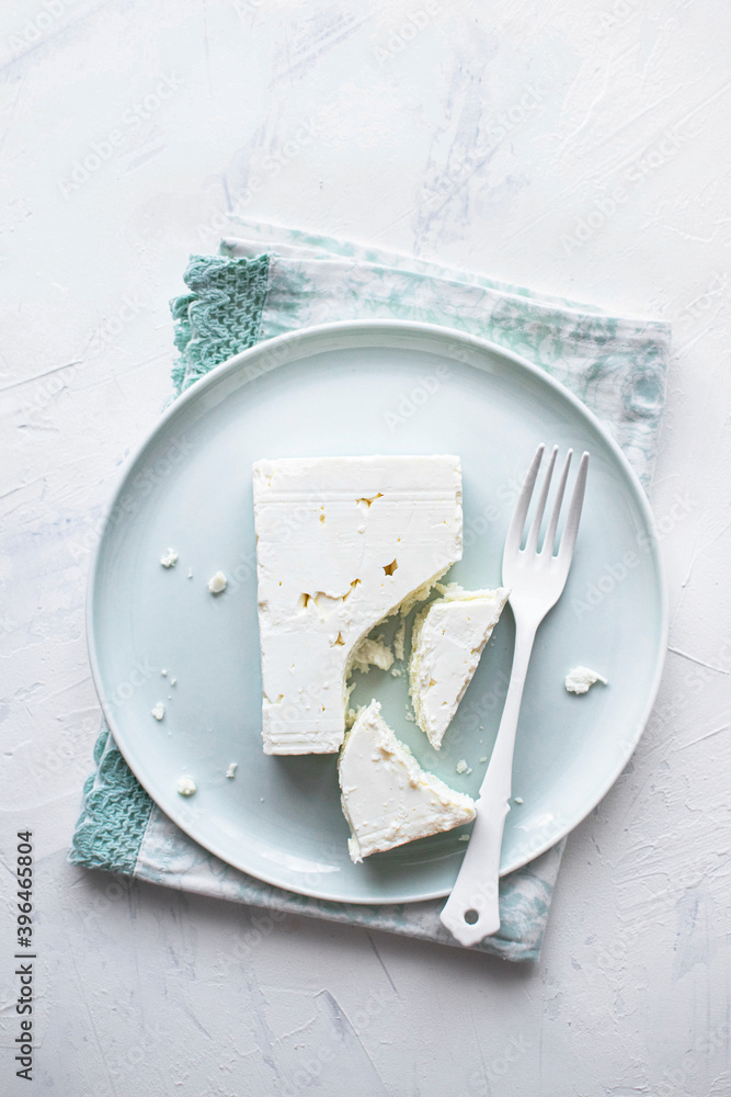 Feta cheese on a  white plate with fork flat lay