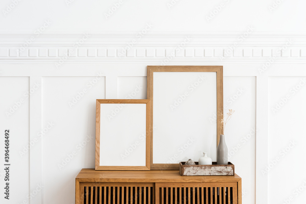 Two picture frames on a wooden sideboard