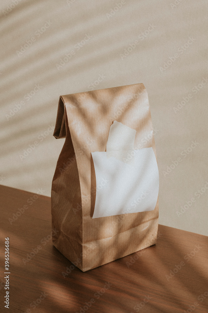 Brown paper bag with a blank white notepaper