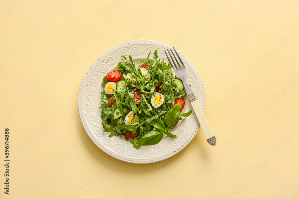 Plate with tasty arugula salad on color background