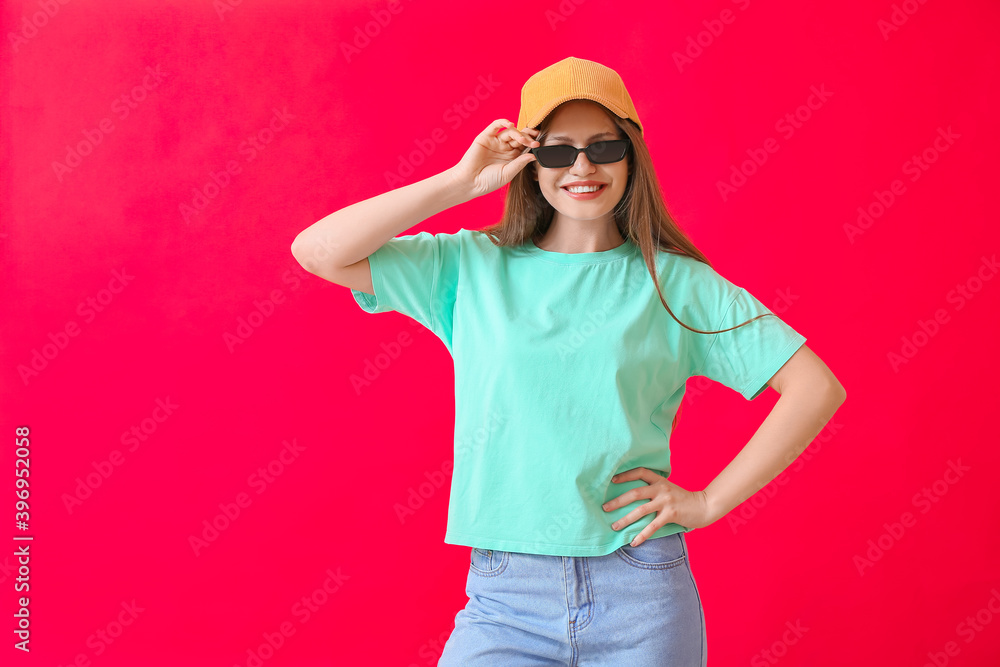 Beautiful woman with stylish sunglasses on color background