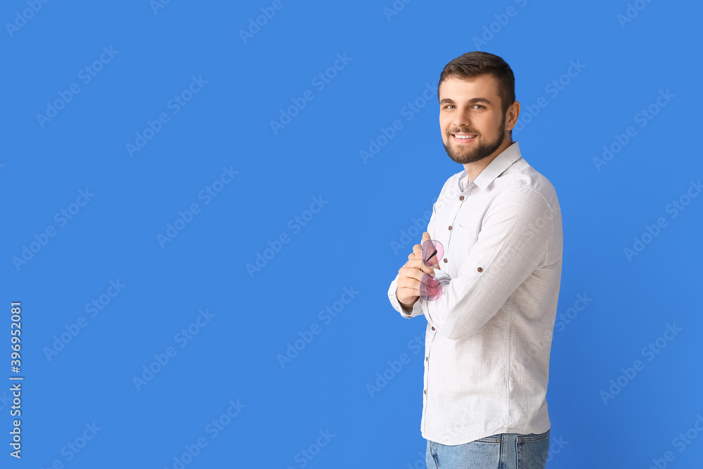 Handsome man with stylish sunglasses on color background